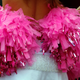 Cheerleader holds pink pom poms